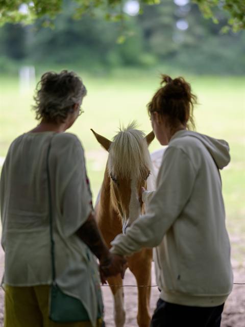 Petra en haar dochter samen bij een paard